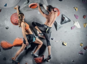 male-and-female-climbing-on-a-climbing-wall