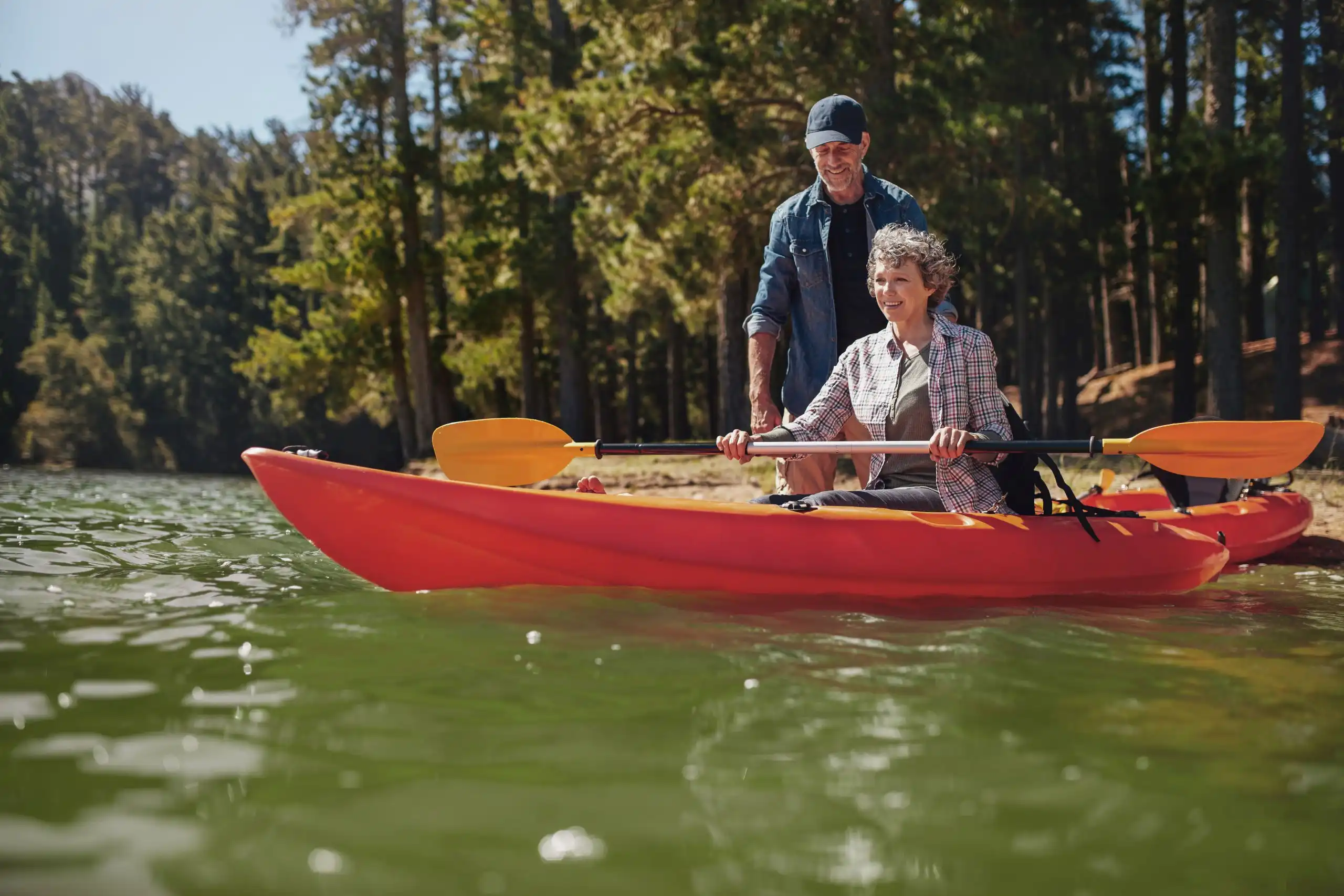 a senior woman getting kayaking lessong from a man-Best way to kayak with bad stiff knees