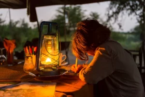 Six year old boy writing a journal by lantern light-Best camping lantern